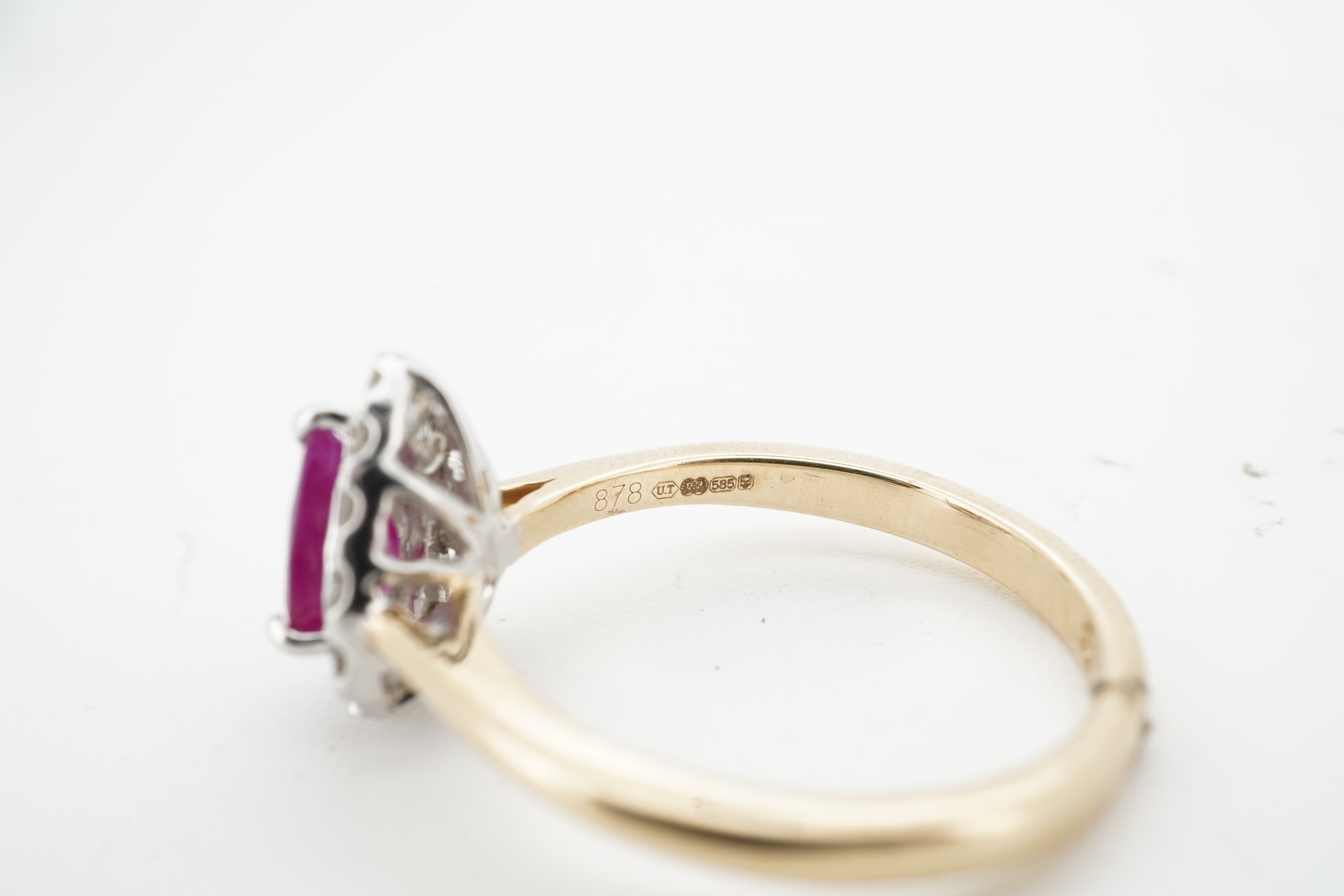 A ruby and diamond cluster ring, claw-set with a pear-shaped ruby weighing approximately 0.60 carats, within a border of brilliant-cut diamonds totalling approximately 0.42 carats, mounted in 14ct gold, size N, British h